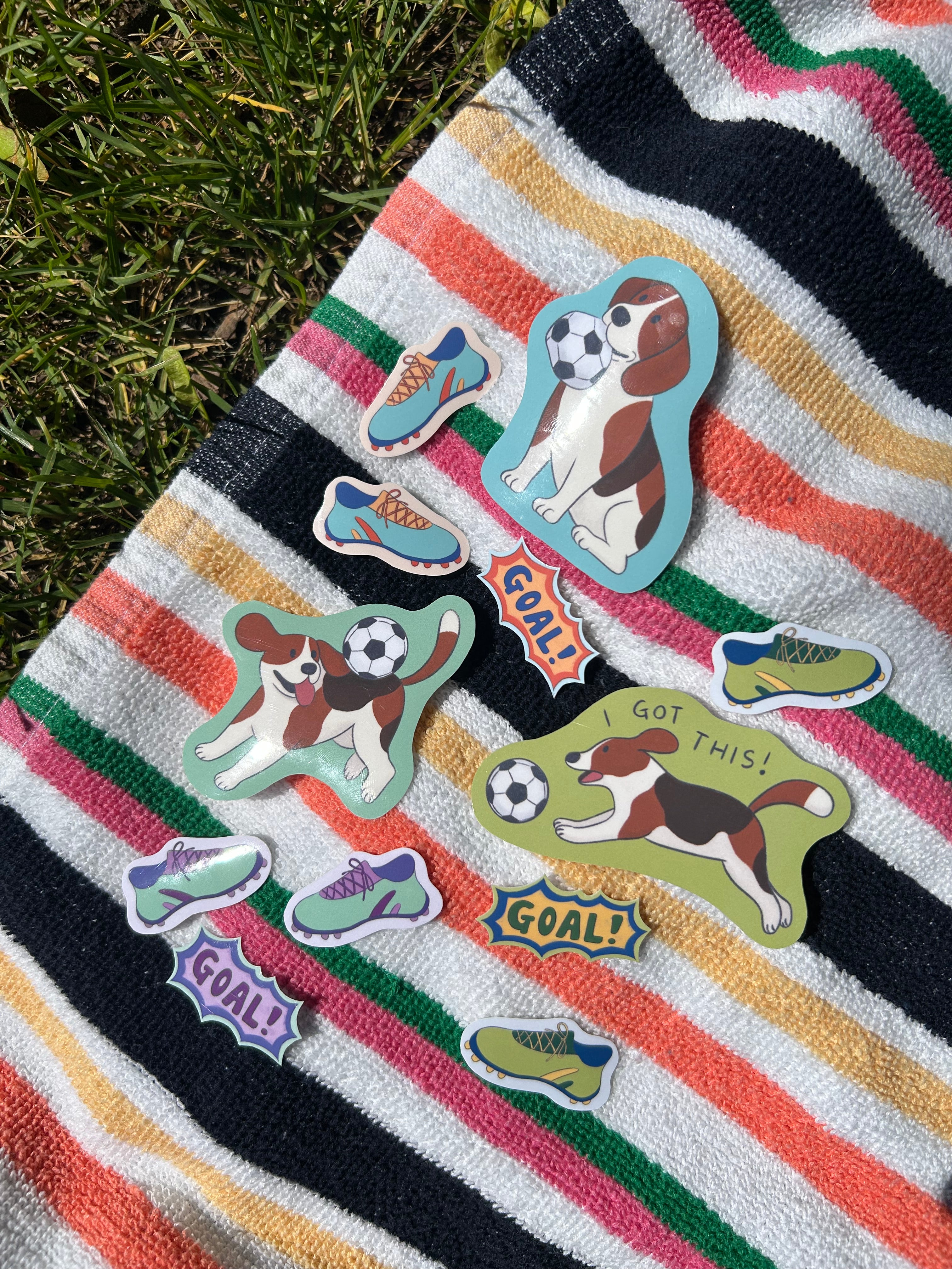 Striped towel with dog-themed stickers on a grassy background
