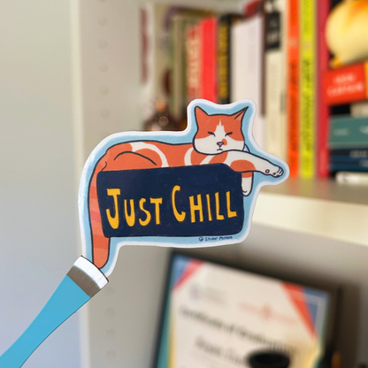 Cat-shaped sign with 'Just Chill' text on a bookshelf background